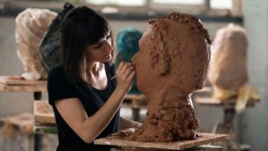 Femme qui fait un sculpture d'un buste