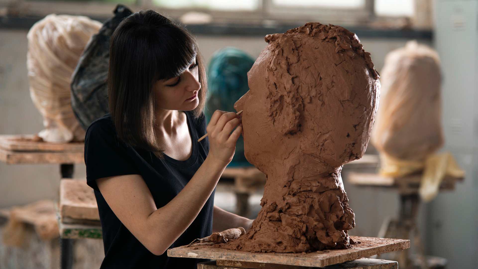 Femme qui fait un sculpture d'un buste