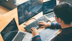 Homme en train de coder sur son ordinateur