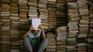 Jeune homme avec des tas de livres